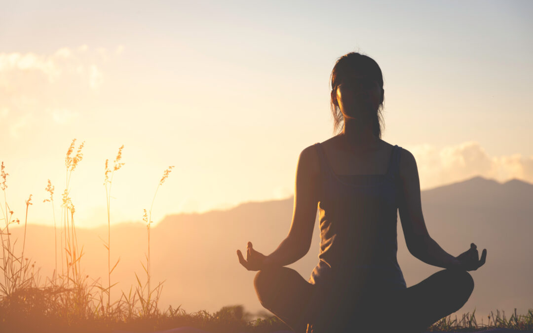 woman doing yoga outdoors on a nice day during sunset for physical and mental health benefits